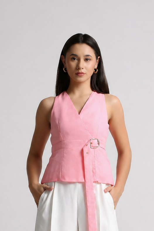 Woman wearing a pink top and white pants on a gray background